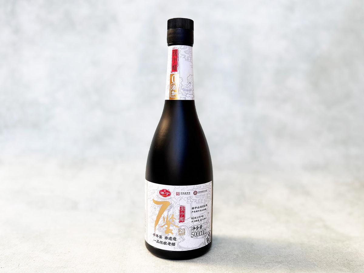 a bottle of Baoning vinegar in black glass with a white label