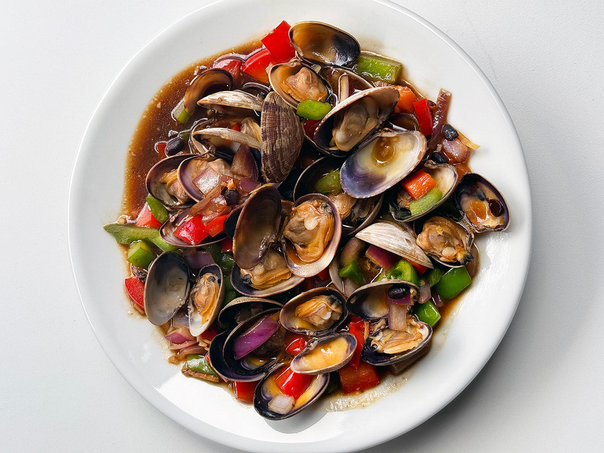 Clams in black bean sauce in a white bowl