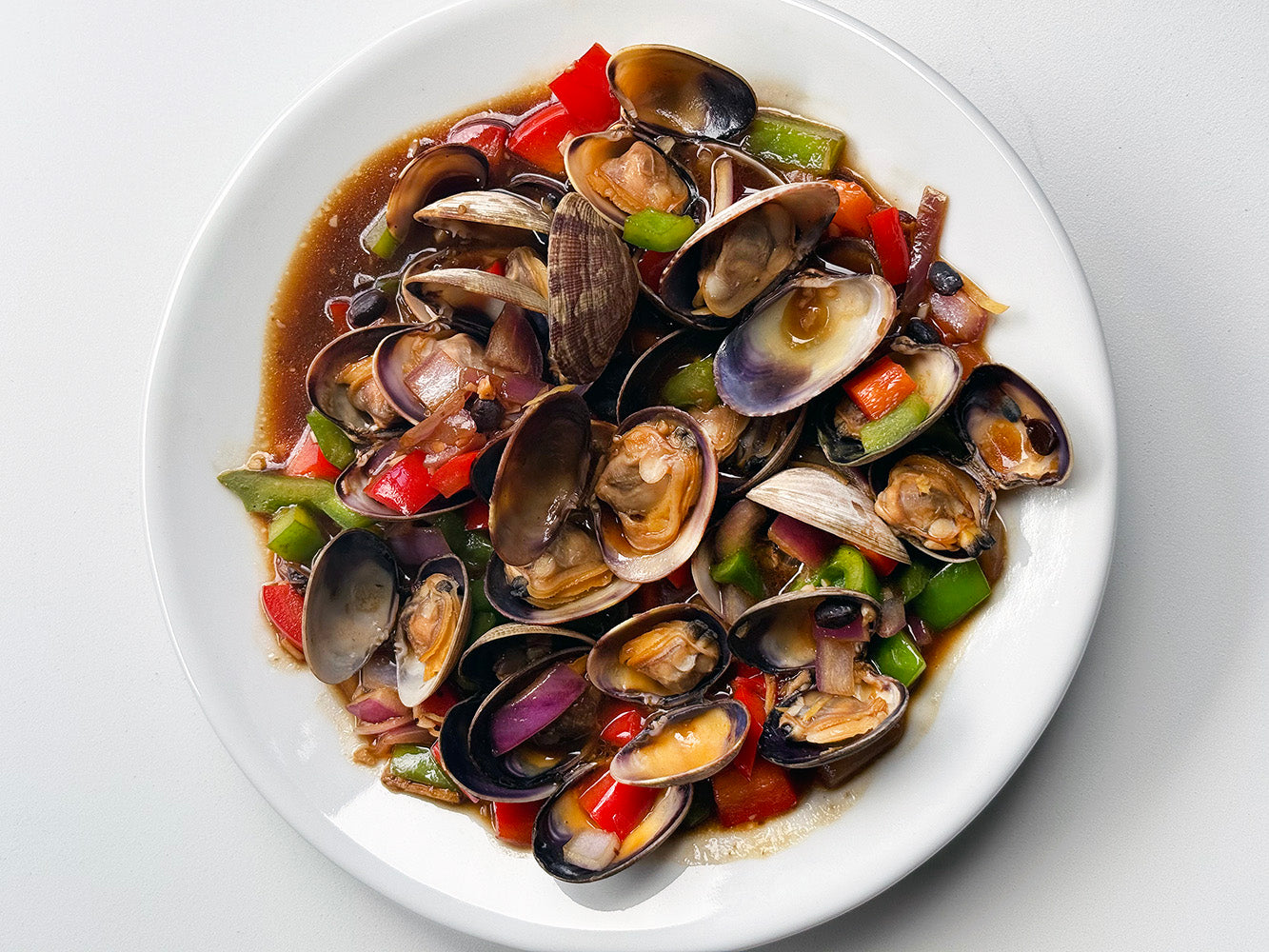Clams in black bean sauce in a white bowl