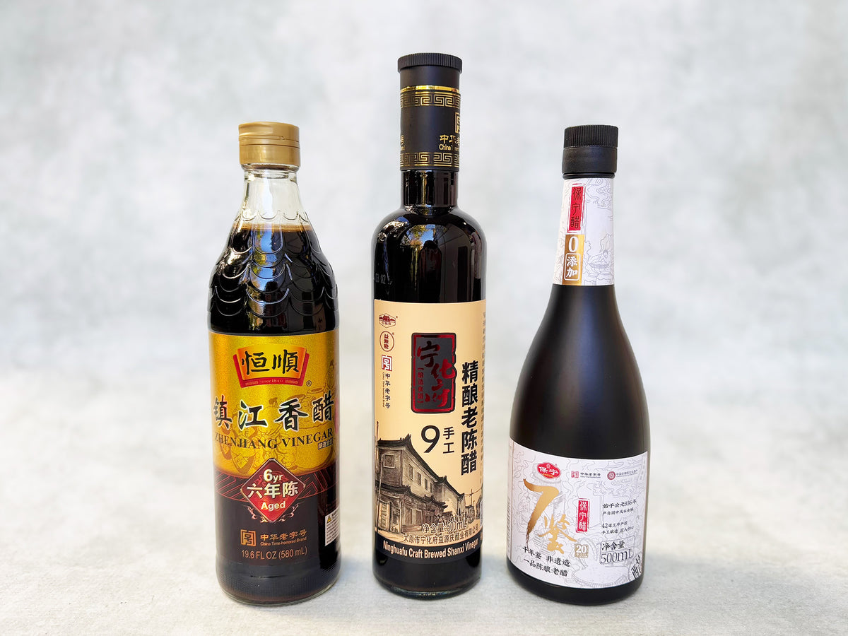 a collection of three Chinese vinegars in glass bottles