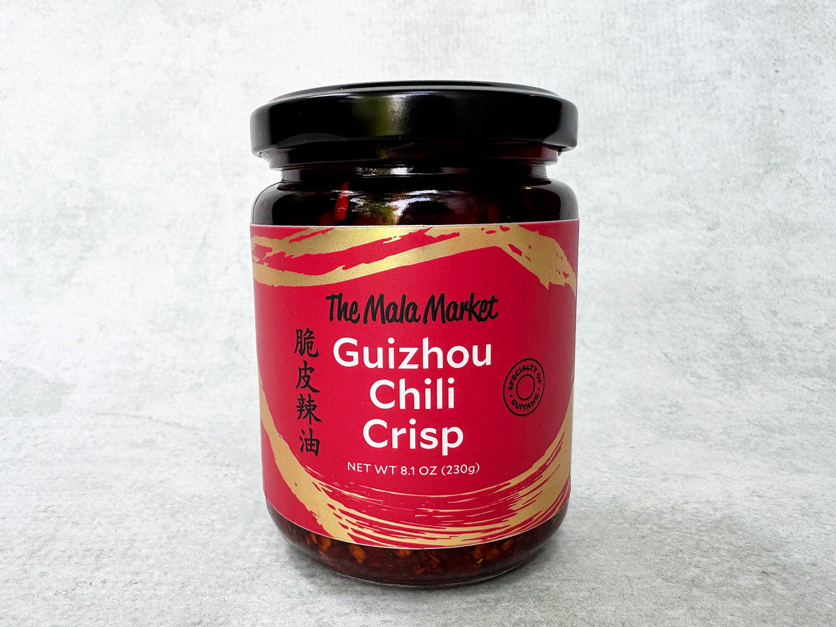 a glass jar of Mala Market Chili Crisp made in Guizhou with a red label