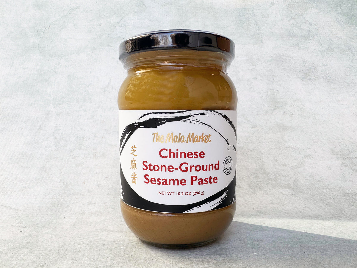 A glass jar of The Mala Market Chinese Stone-Ground Sesame Paste with a label showing the brand name and product name.