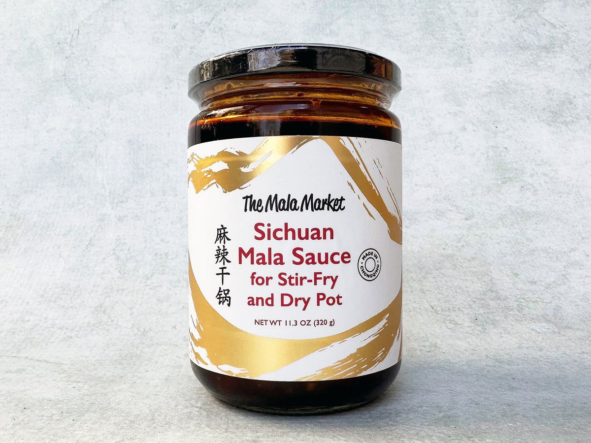 a glass jar of Mala Market dry pot sauce with a white and gold label