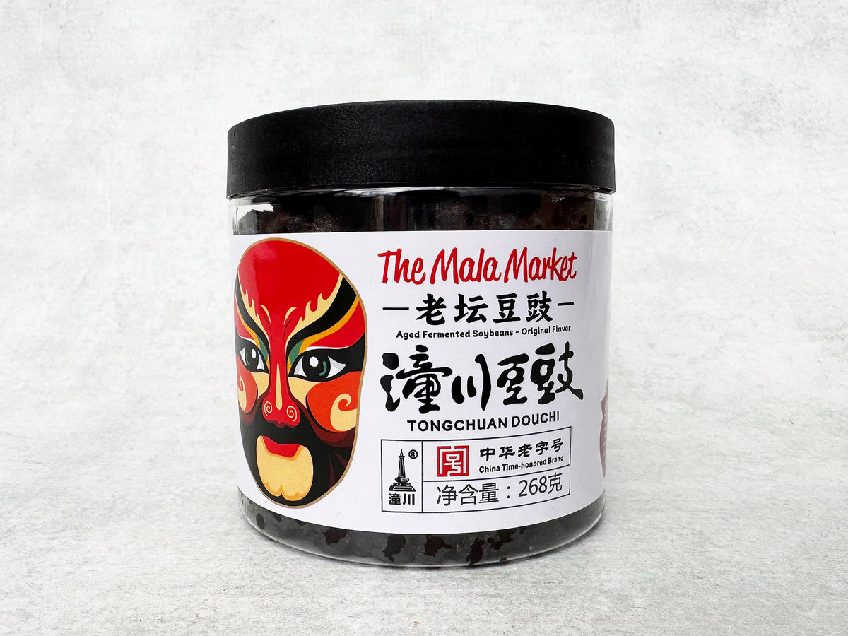 a plastic jar of aged fermented soybeans with a Chinese opera mask on the label