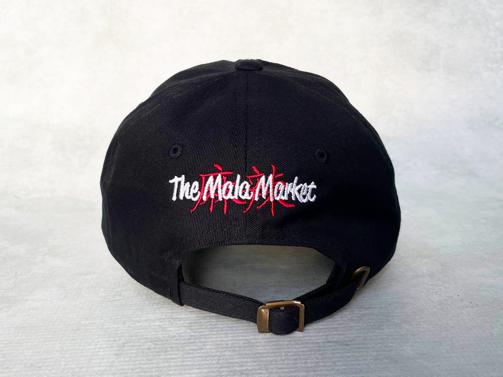 black cotton cap with The Mala Market logo embroidered in red and white on the back