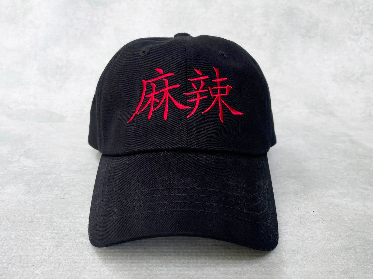 A black cotton cap with red embroidered Chinese characters for mala on the front 