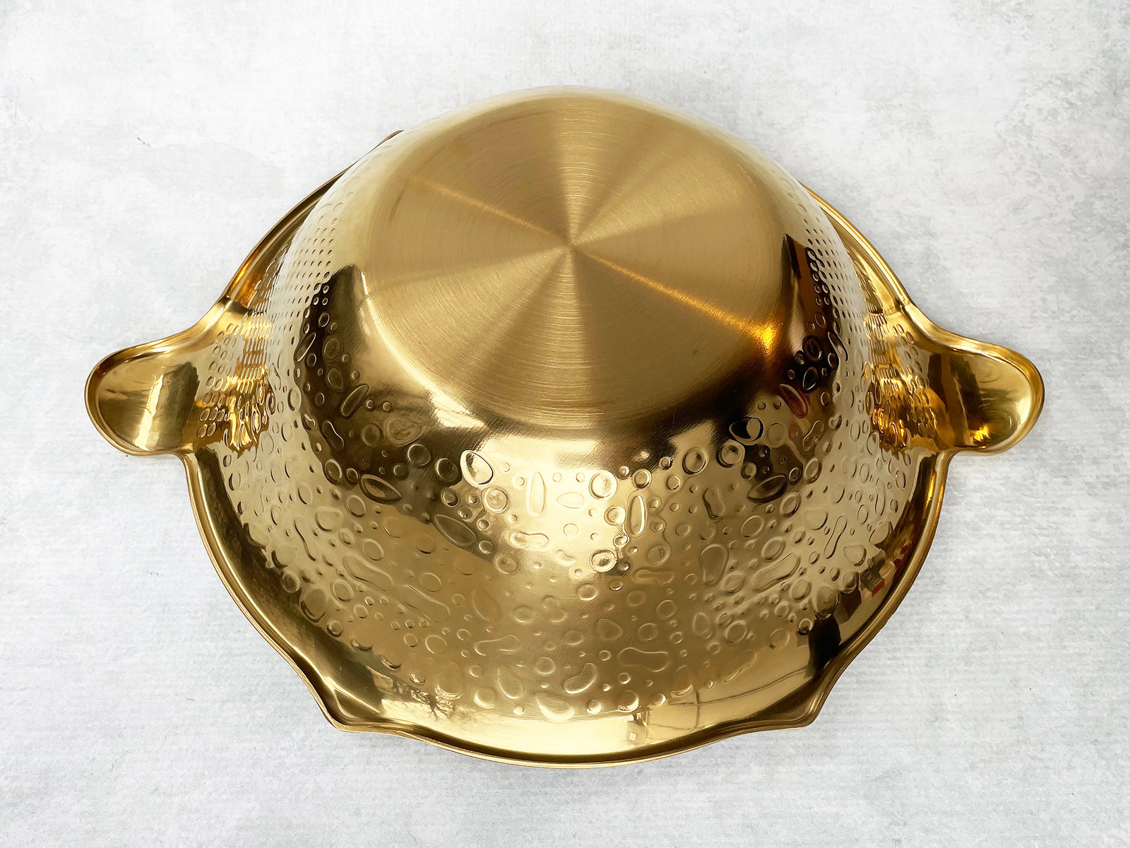 Upside-down hot pot showing a flat bottom and outward-sloping bowl. 