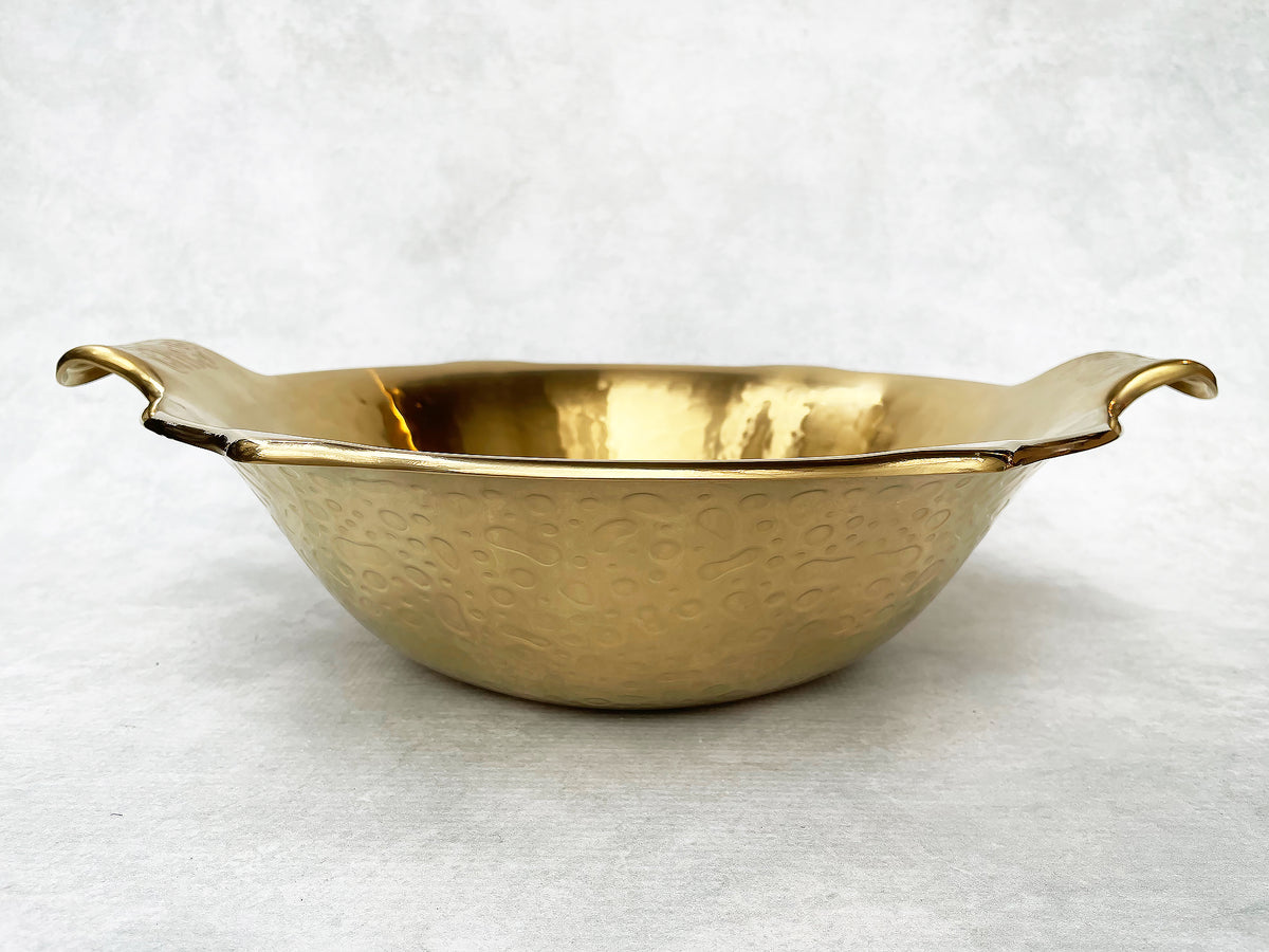 Side view of a gold hot pot showing its deep bowl shape and short handles. 