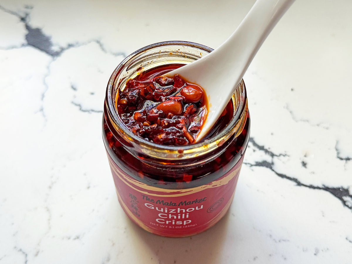 Guizhou chili crisp being scooped with a spoon out of an open jar