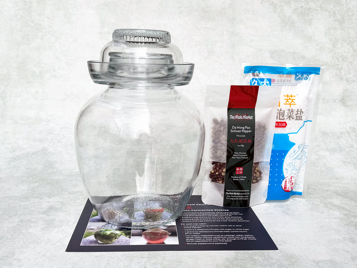 an egg-shaped glass jar with a flat bottom and a glass cap, a bag of spice and a bag of salt