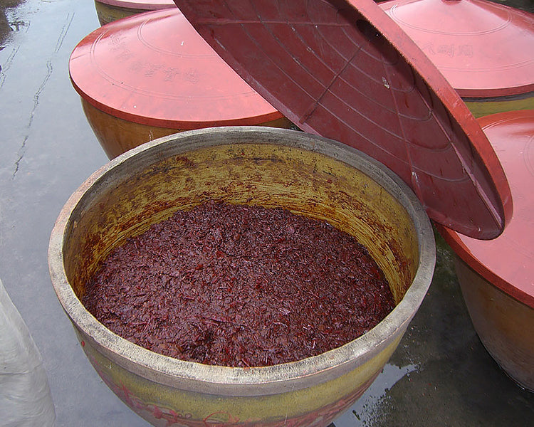 Pixian doubanjiang in a clay crock with the lid lifted
