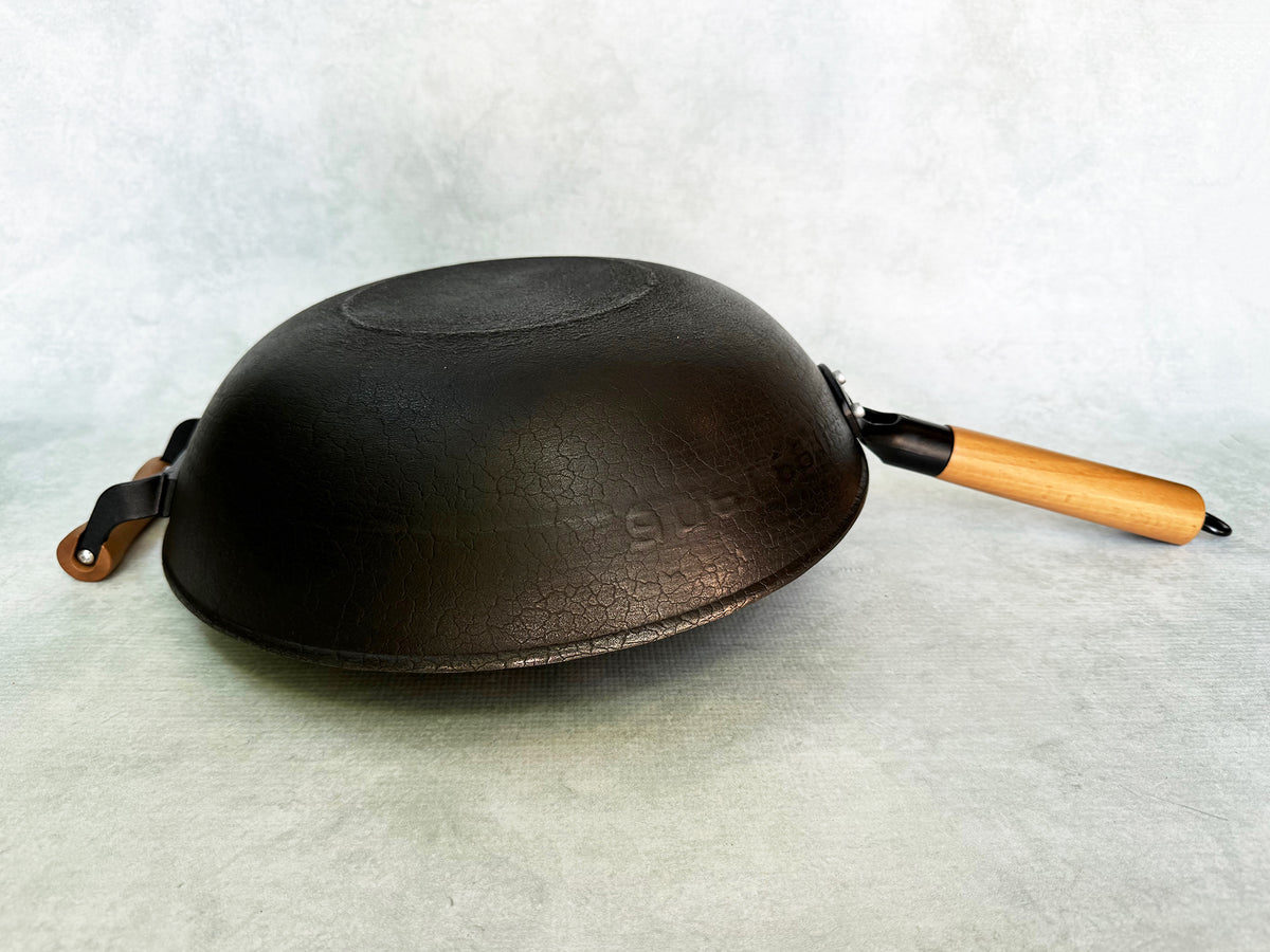 upside-down wok showing flat bottom and cracked turtle-pattern metal texture