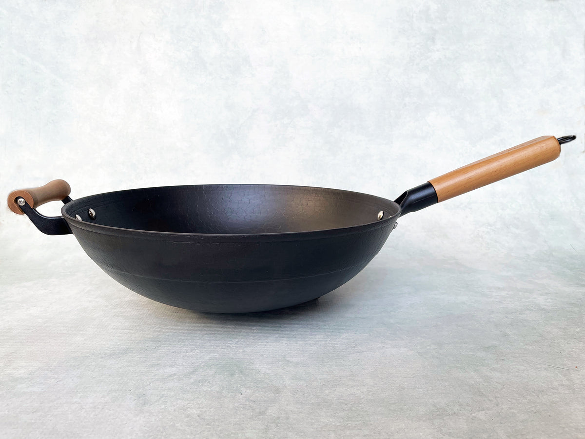 a side view of a round bottom cast iron wok