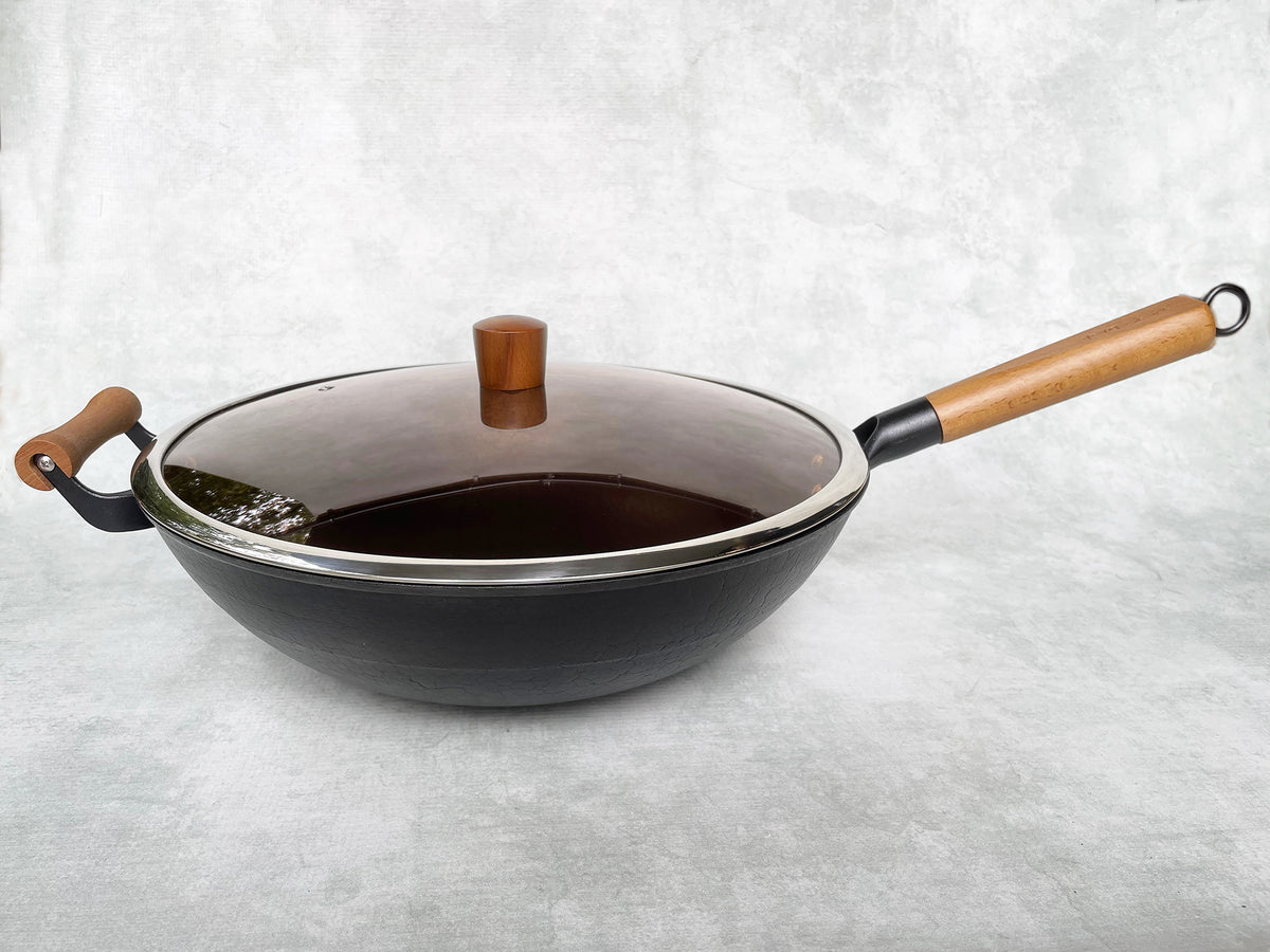 cast iron wok with a glass lid shown from the side