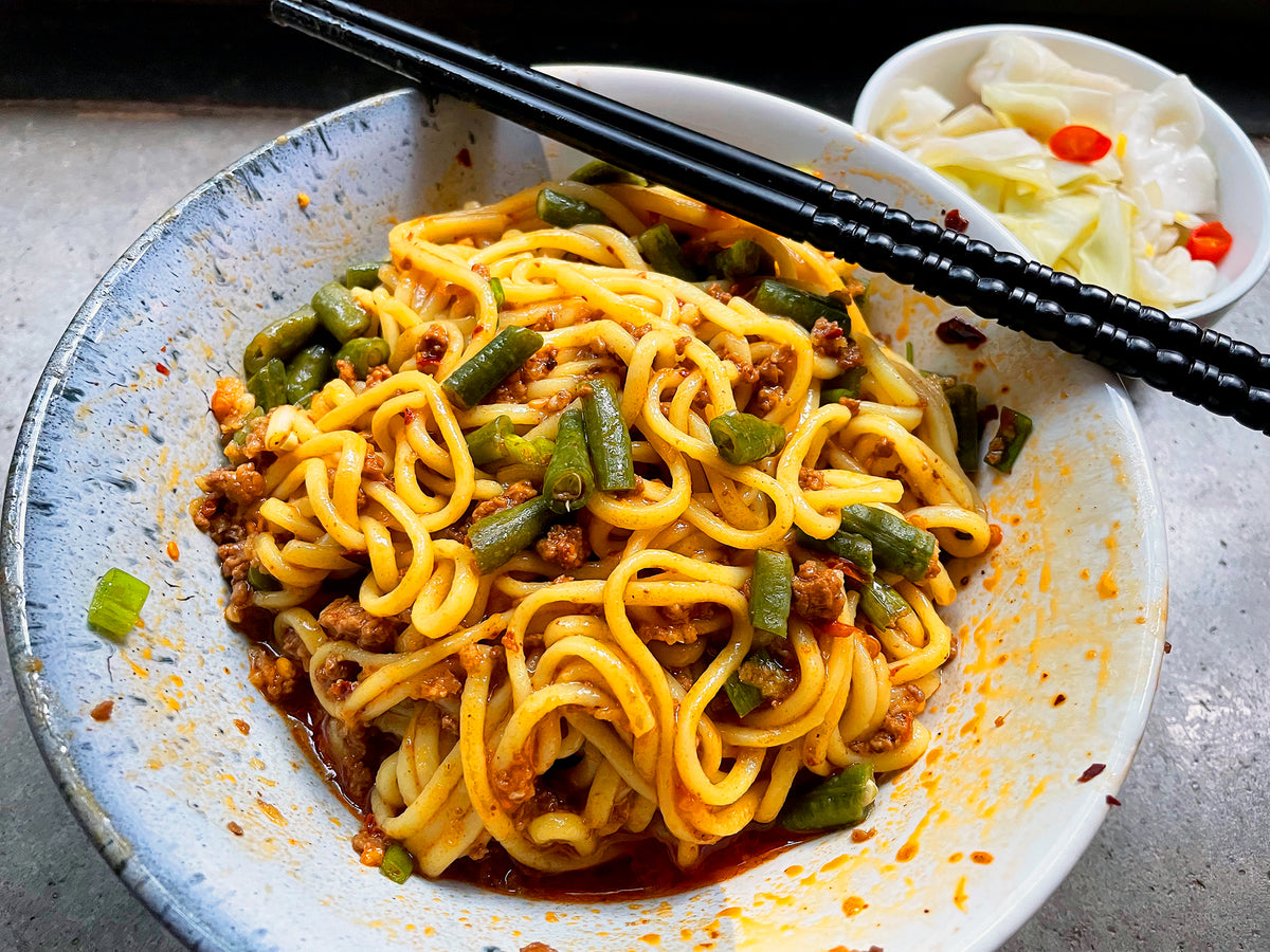 a bowl of alkaline noodles with pork, stirred up