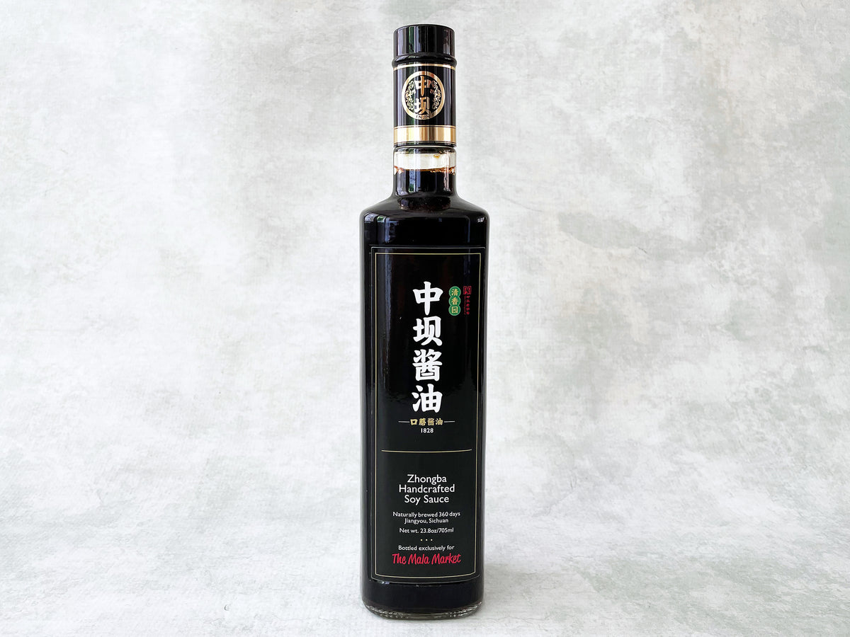 a tall glass bottle of Zhongba Handcrafted Soy Sauce made for The Mala Market with a black and white label 