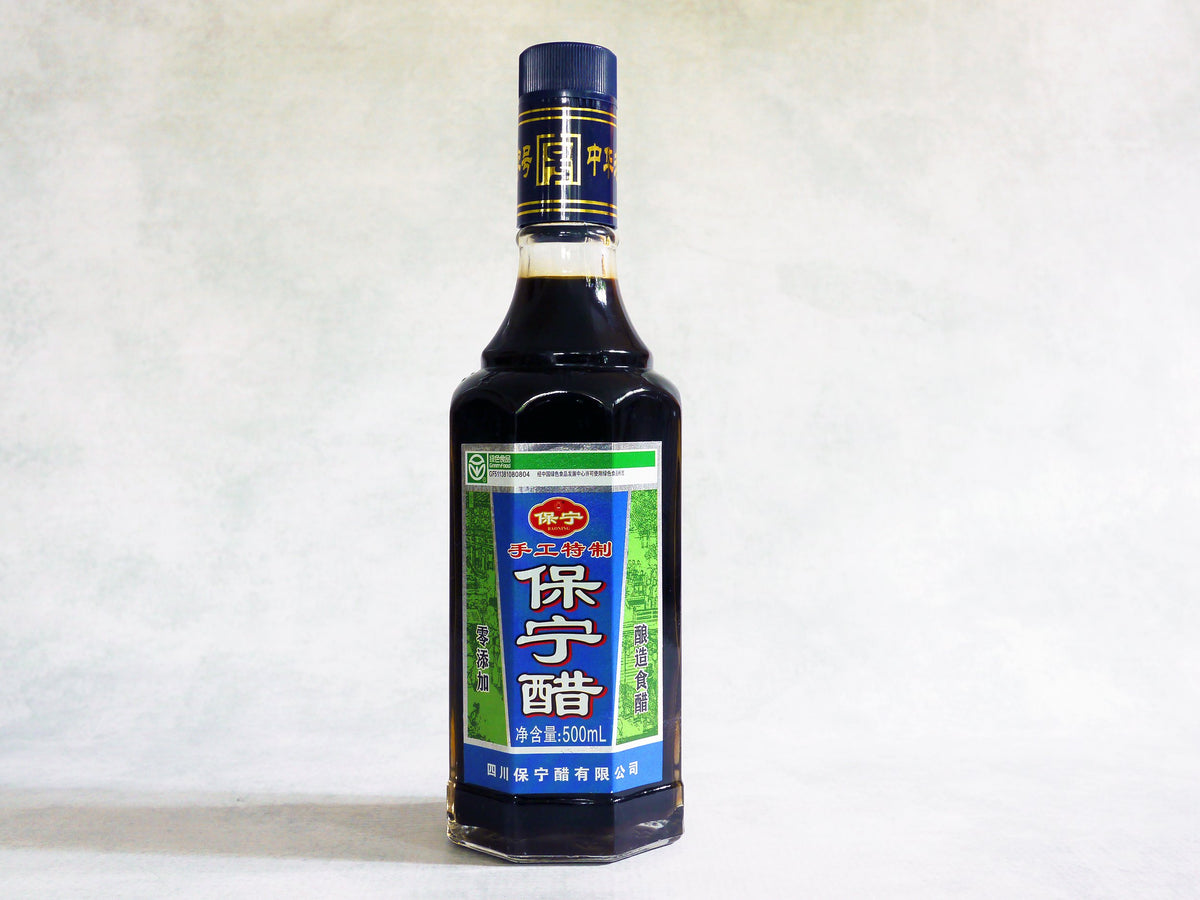 a glass bottle of Baoning vinegar with a blue and green label and Chinese characters