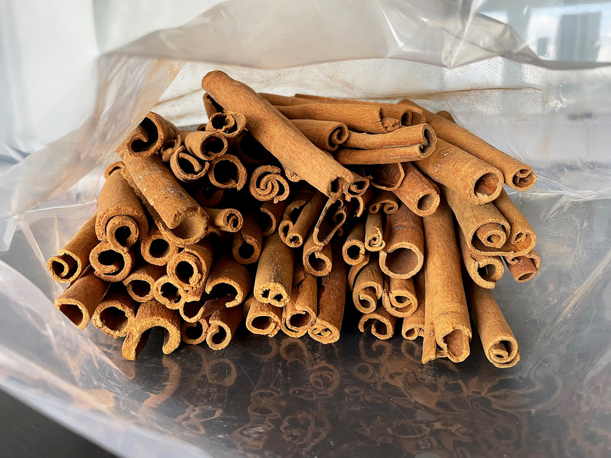 a large plastic wholesale bag holding many quills of rolled cassia bark