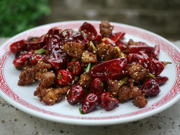 a plate of fried chicken with dried lantern chilies