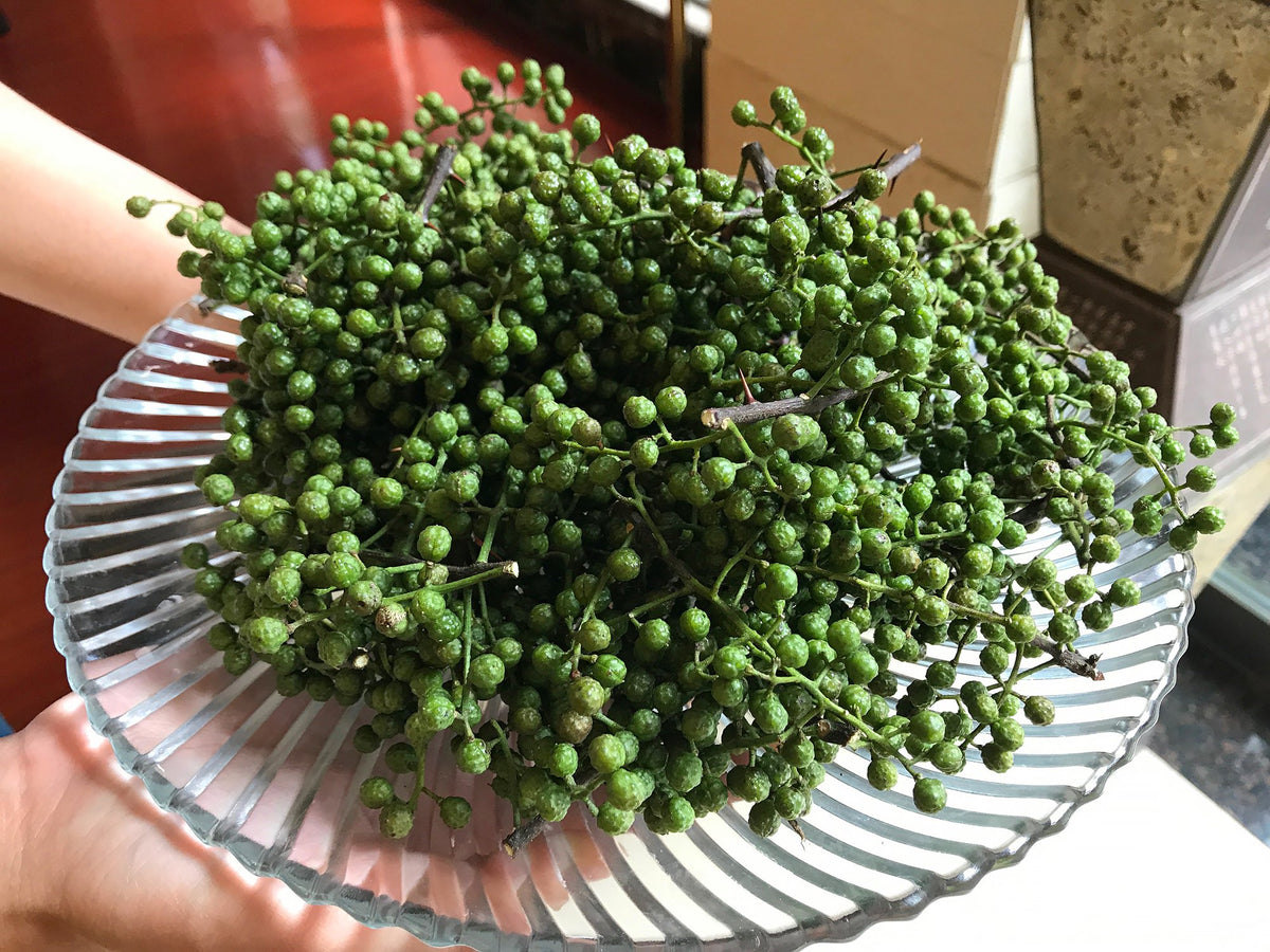 a large bunch of just picked green Sichuan pepper on a plate