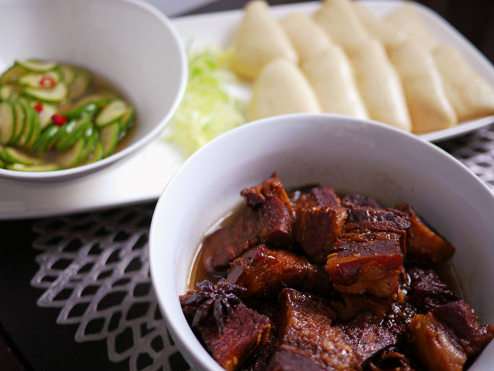 a bowl of red braised pork belly made with dark soy sauce 