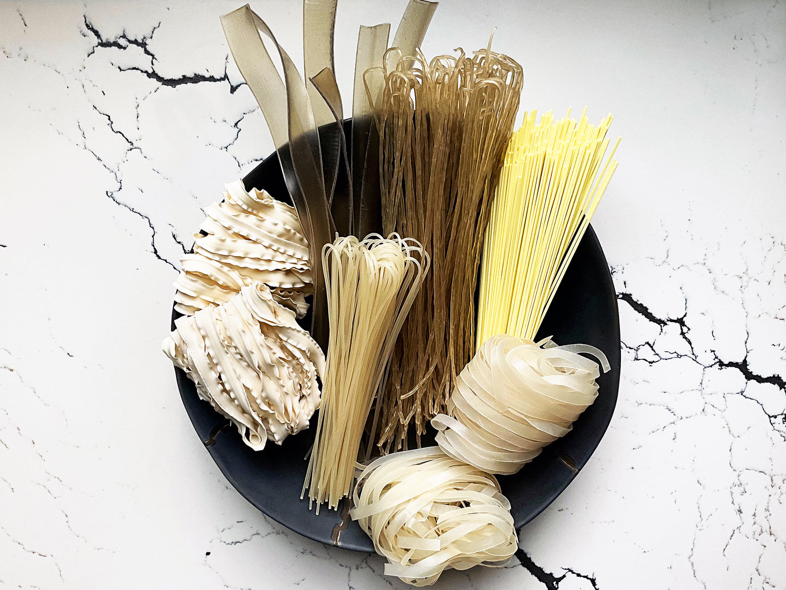 six kinds of Chinese dried noodles unwrapped and displayed in a bowl