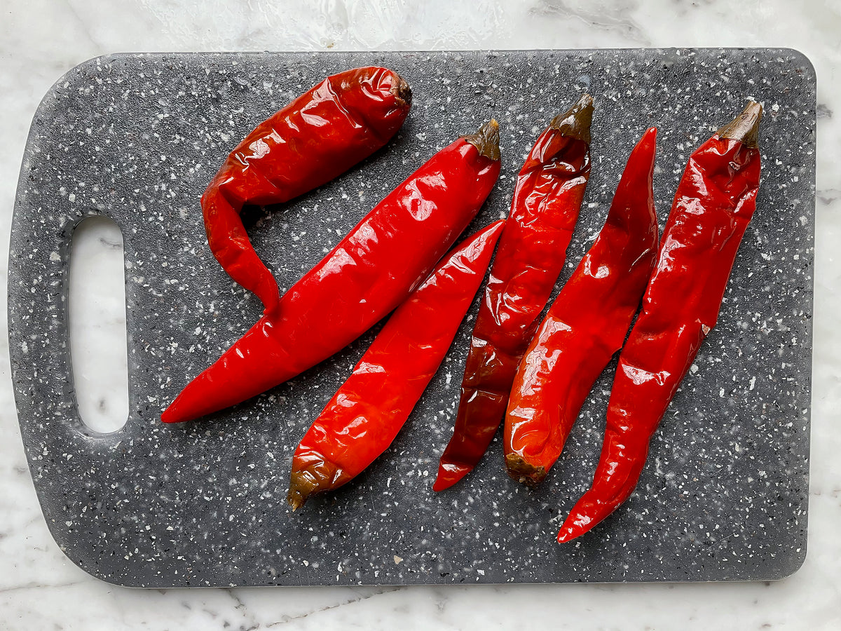 six Sichuan pickled chilies (pao la jiao) on cutting board