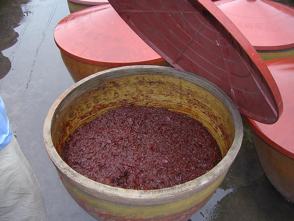 a closeup of a clay crock holding Pixian doubanjiang