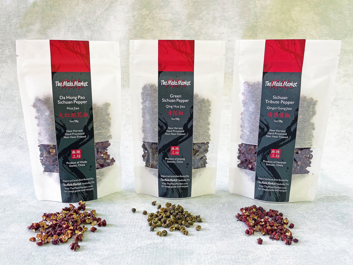 three small white kraft bags of Sichuan peppercorns with their contents displayed in front of them, including red da hong pao, green, and red tribute