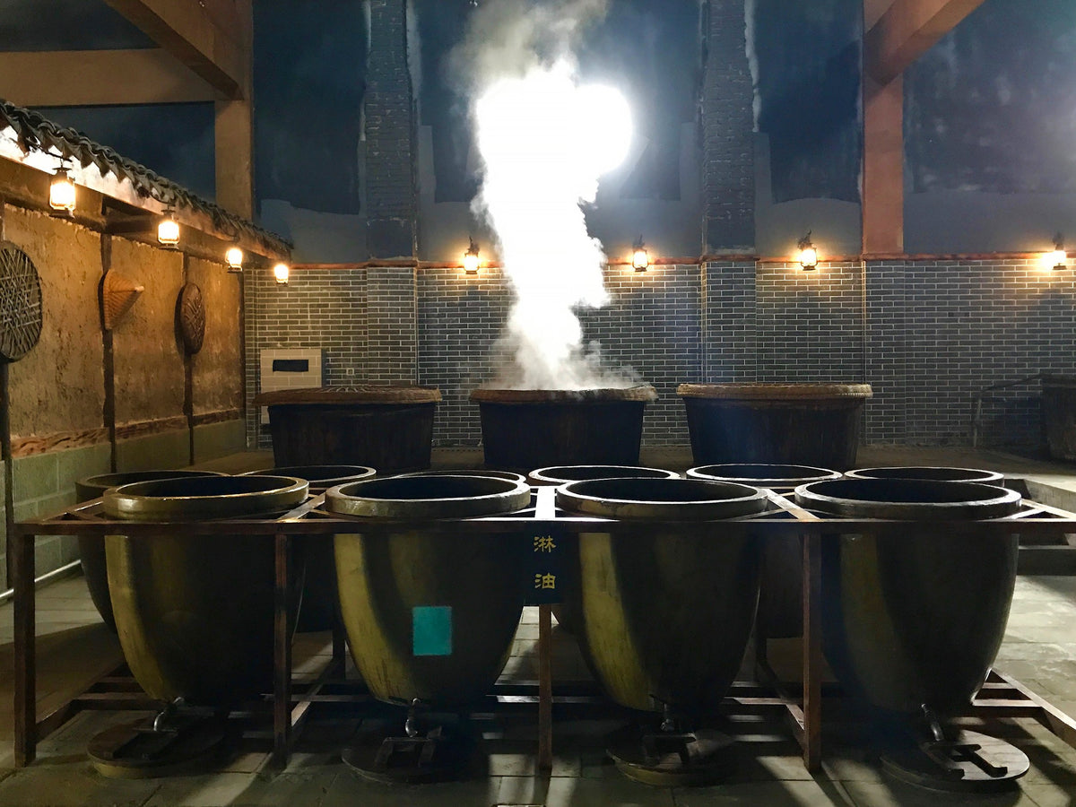 the Zhongba soy sauce factory in Sichuan, showing cooking cauldrons with steam rising
