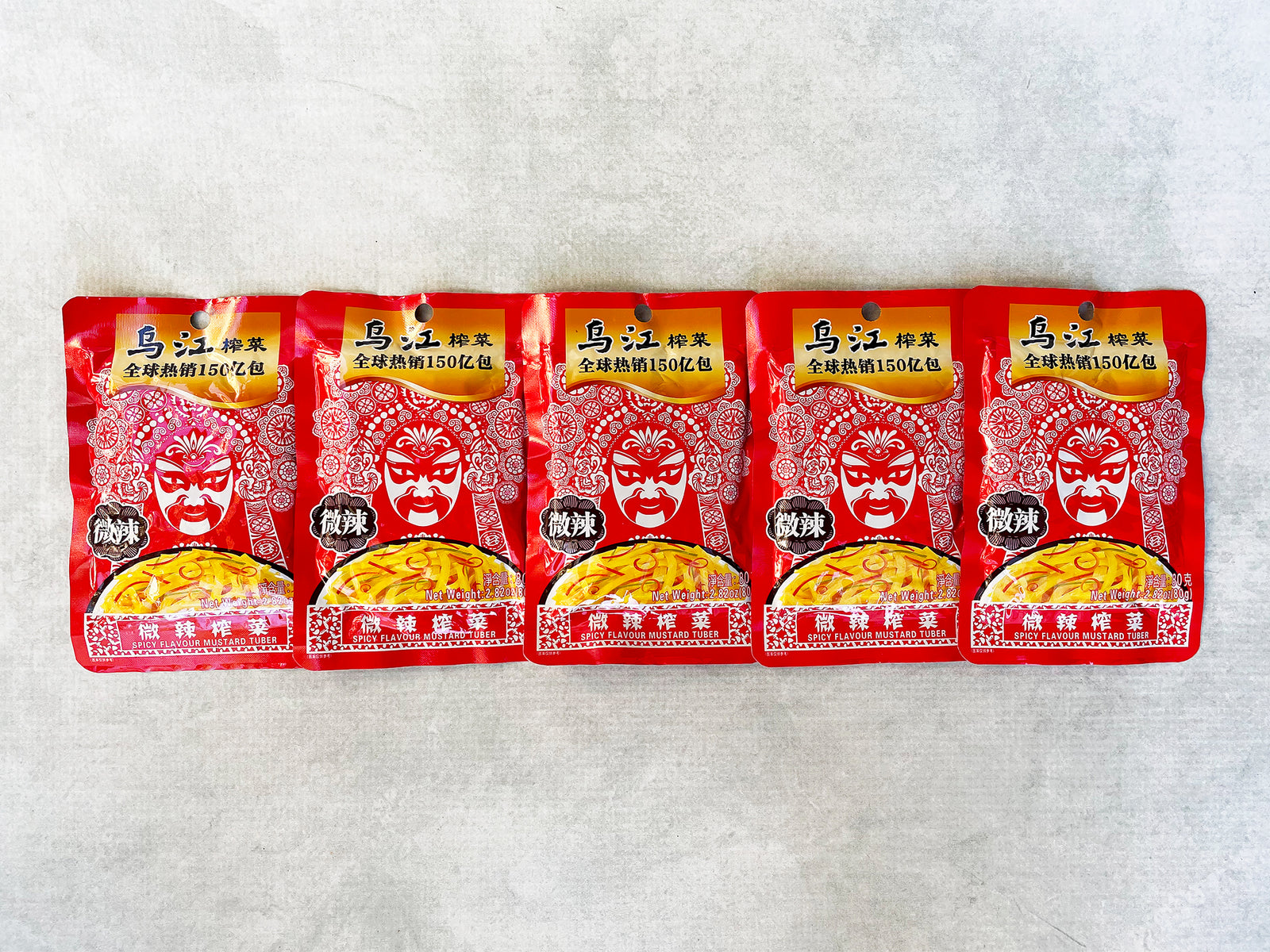  a set of five small foil packages of mustard tuber pickles that are red with a Sichuan opera mask on the front
