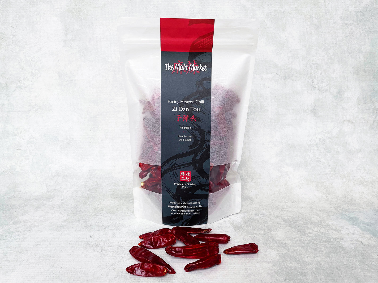 a tall white kraft bag of facing heaven zi dan tou chilies and several dried facing heaven chilies displayed in front of the bag 